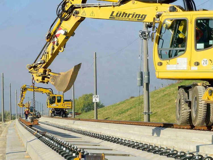 Photo: High-speed railway line Erfurt–Leipzig/Halle: two yellow excavators work on a slab track section.